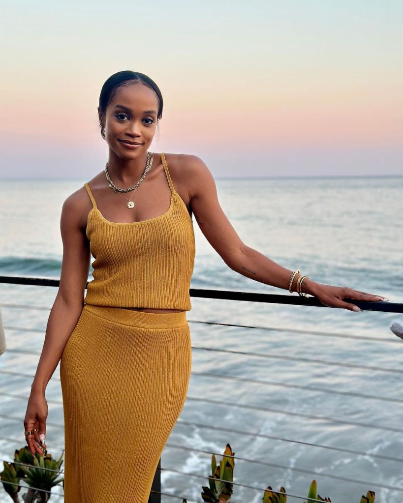 Rachel Lindsay standing on the balcony in a yellow dress